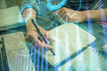 Financial chart drawn over hands taking notes background. Concept of research. Double exposure