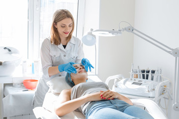The beautician will break up the nourishing cream for the patient's face mask. Moisturizing,...