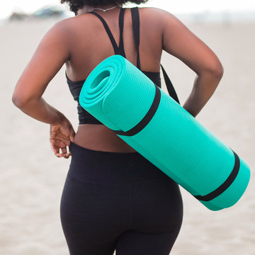 Rear view of woman carrying yoga mat