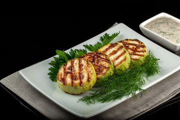 Concept for a healthy summer diet: baked zucchini with dill sauce