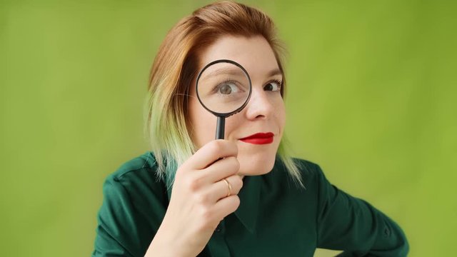Search. A young woman with a magnifying glass searches, investigates and studies.