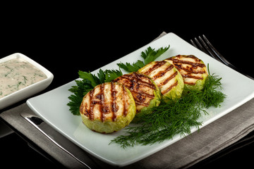 Concept for a healthy summer diet: baked zucchini with dill sauce