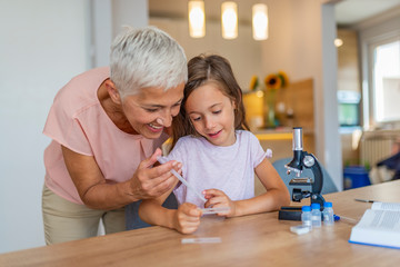 Doing chemical experiment with my grandmother. Child with her granny preparation for scientific...