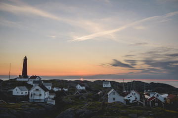 Island village with lighthouse at sunset