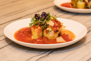 Cannelloni with a gentle cream of ricotta, spinach and cherry tomato sauce on a tareka. Cooking in a restaurant