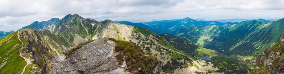 Fototapeta Panoramic view from Placlive peak on Western Tatra mountains or Rohace panorama. Sharp green mountains and lake rohacske pleso, ostry rohac, hruba kopa and volovec with hiking trail on ridge. Summer obraz