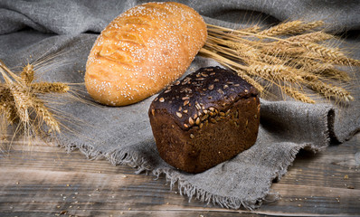 Fresh fragrant bread on a wooden table at sunset. Homemade hot pastry with.