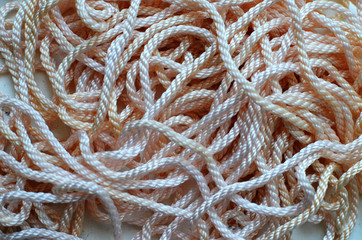 Nylon rope in coils spagetti like of beige colors, abstract background
