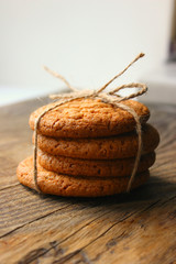 Homemade oatmeal cookies on an old wooden table, rustic style. Oatmeal and cinnamon sticks. Copy space.