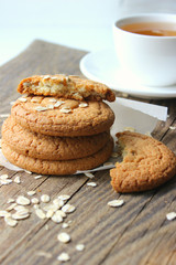 Homemade oatmeal cookies on an old wooden table, rustic style. Oatmeal and cinnamon sticks. Copy space.