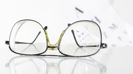 Old glasses on a table in a white room.