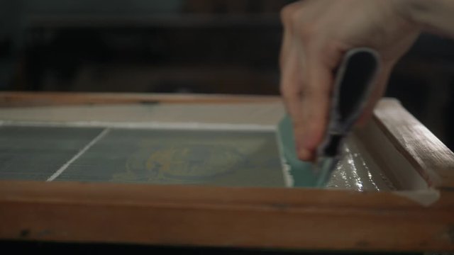 Man close up preparing t-shirt for printing in the silk screen printing machine. Only hands. Man preparing t-shirt for printing in the silk screen printing machine.