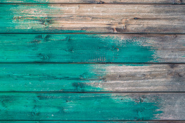 Wooden background texture blue paint partly covering planks.