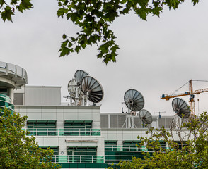 Many Satellite Dishes on Rooftop of a Communicaitons Building