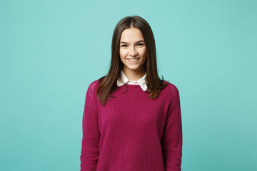 Fototapeta premium Young brunette woman girl in casual clothes posing isolated on blue green turquoise wall background studio portrait. People sincere emotions lifestyle concept. Mock up copy space. Looking camera smile