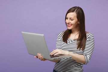 Fototapeta premium Young brunette woman girl in casual striped clothes posing isolated on violet purple background studio portrait. People sincere emotions lifestyle concept. Mock up copy space. Hold tablet pc computer.