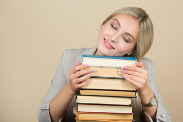 beautiful young woman in a suit sleeps at a table with books
