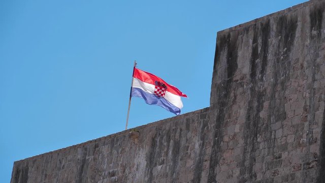 Slow motion, Flag of Croatia on walls of old city of Dubrovnik. National flag of Croatia - Trobojnica or Tricolour, horizontal tricolour of red, white, and blue with Coat of Arms of Croatia in centre