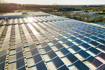 Top view of blue shiny solar photo voltaic panels system producing renewable clean energy abstract background. © bilanol