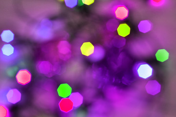 Christmas background. Glowing and festive colored light circles created from in camera and lens bokeh. Christmas fairy lights defocused giving a blurred effect. 