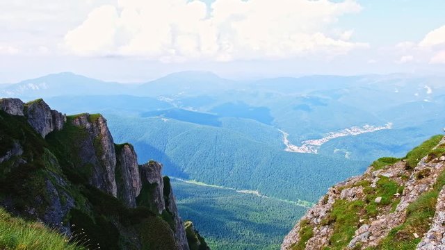 Cinematic shot of the fir, Bucegi mountains, Busteni city and skyline in Romania