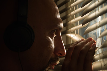 Secret FBI agent Peeps through the blinds and overhears the conversation in the headphones - obrazy, fototapety, plakaty