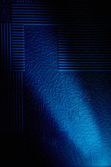 Dark background with a pattern highlighted by a diagonal blue ray of light