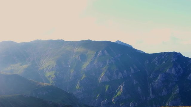 Panorama shot of the Bucegi mountains from above in Busteni city at sunset, Romania
