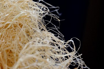 In selective focus a pile of dried hay with dark background and warm light