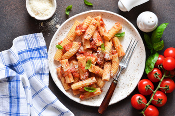 Pasta with tomato sauce and basil. Pasta tartilloni on a dark background.