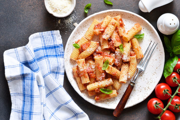 Pasta with tomato sauce and basil. Pasta tartilloni on a dark background.