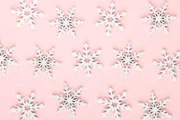 Christmas background. White snow decorations on a pink background.