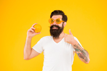 Say yes to health food. Bearded man showing thumbs up to orange. Hipster gesturing like to fruit...