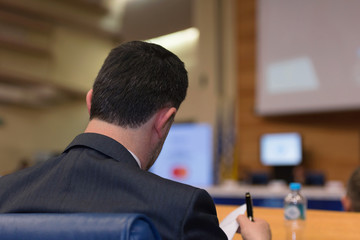 Businessman at business conference room with public giving presentations. Audience at the...