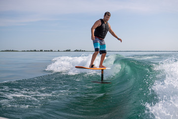 Man wake surfing with foil board.