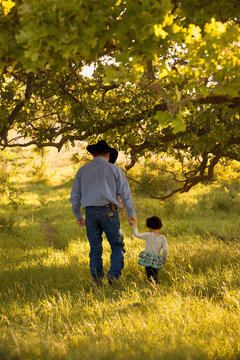 Grandfather and granddaughter walking in the field