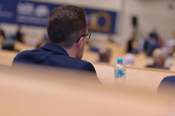 Businessman at business conference room with public giving presentations. Audience at the...