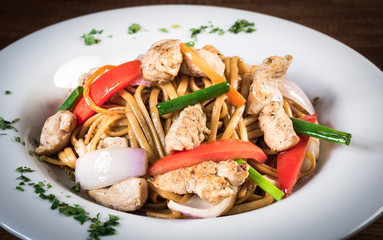 Tallarin saltado traditional peruvian meal. On a white plate