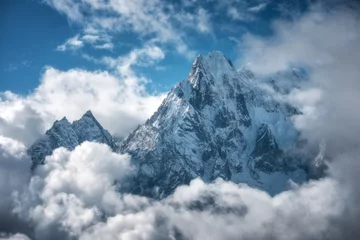 Foto auf Acrylglas Manaslu Manaslu mountain with snowy peak in clouds in sunny bright day in Nepal. Landscape with high snow covered rocks and blue cloudy sky. Beautiful nature. Fairy scenery. Aerial view of Himalayan mountains