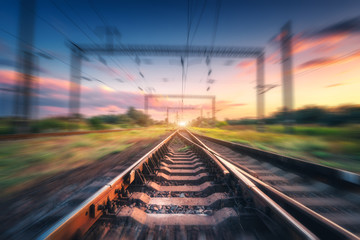 Plakat Railroad and beautiful blue sky with clouds at sunset with motion blur effect in summer. Industrial landscape with railway station and blurred background. Railway platform in speed motion. Concept