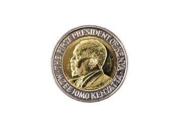 A close up image of a bimettalic twenty Kenyan shilling coin isolated on a white background