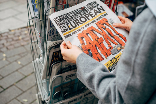 STRASBOURG, FRANCE - OCT 28, 2017: Woman Buying The New European Newspaper At Press Kiosk Featuring BREXIT Red Text On Cover