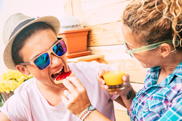 caucasian guy and adult woman at home in the terrace having breakfast together with a funny face of...