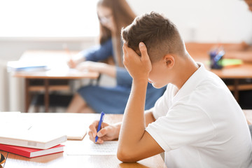 Teenage boy passing school test in classroom