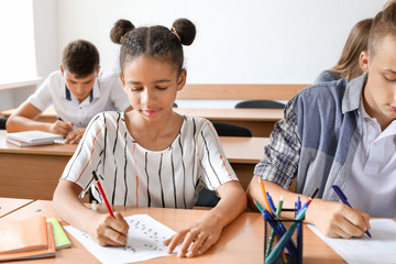 Pupils passing school test in classroom