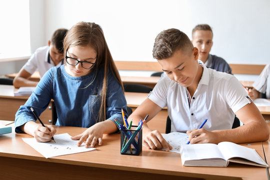 Pupils Passing School Test In Classroom