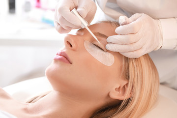 Young woman undergoing procedure of eyelashes lamination in beauty salon - obrazy, fototapety, plakaty