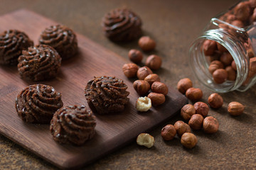 Truffle chocolate mini-cakes on a rusty metal surface, bank with a filbert. Sweets and nuts