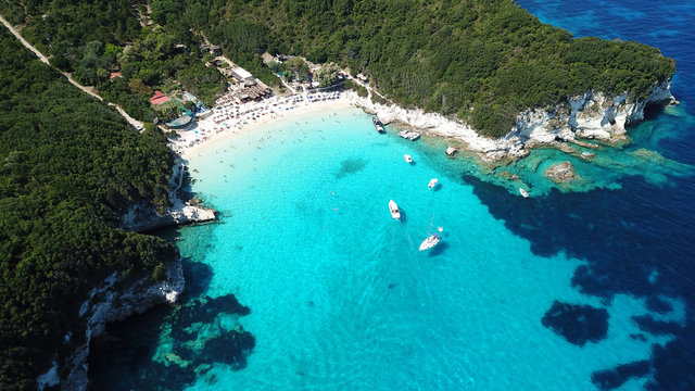 Aerial drone photo of tropical paradise turquoise beach of Voutoumi with sail boats docked in island of Anti paxos, Ionian, Greece © aerial-drone