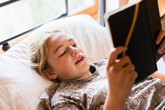 13 year old girl reading in bed